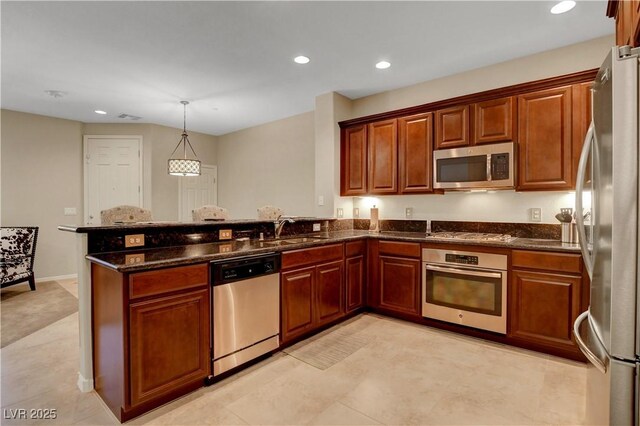 1560 Plaza Centre Dr Unit 103, Las Vegas, NV 89135 - kitchen with appliances with stainless steel finishes, a peninsula, a sink, recessed lighting, and dark stone countertops