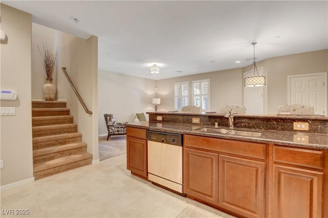 1560 Plaza Centre Dr Unit 103, Las Vegas, NV 89135 - kitchen with dishwasher, a sink, dark stone countertops, decorative light fixtures, and brown cabinetry