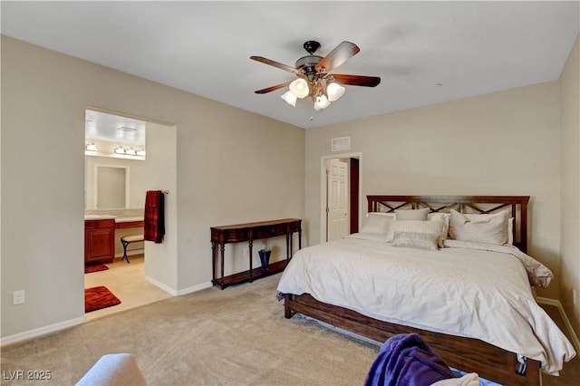 1560 Plaza Centre Dr Unit 103, Las Vegas, NV 89135 - bedroom with light colored carpet, baseboards, connected bathroom, and a ceiling fan