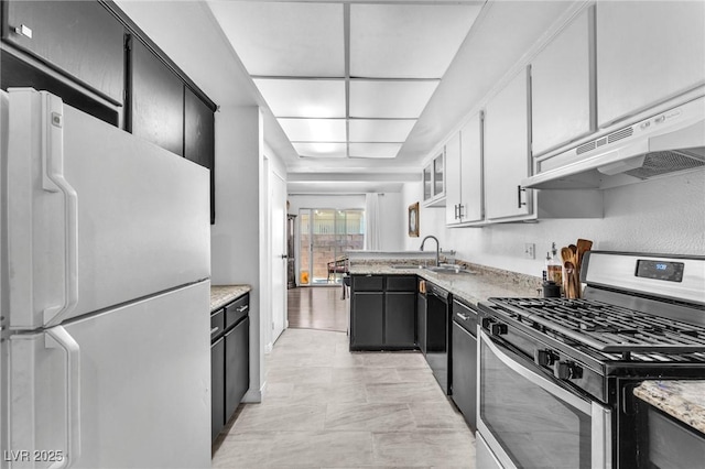 110 Huckleberry Ln, Henderson, NV 89074 - kitchen featuring stainless steel gas range oven, freestanding refrigerator, under cabinet range hood, a sink, and dishwasher