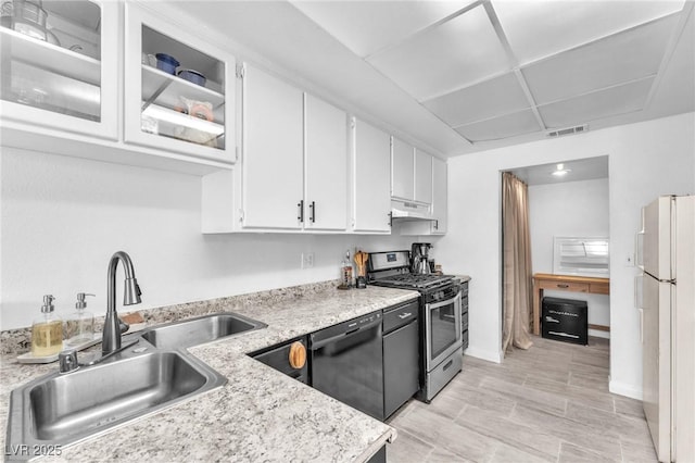 110 Huckleberry Ln, Henderson, NV 89074 - kitchen featuring stainless steel gas range, black dishwasher, freestanding refrigerator, a sink, and under cabinet range hood
