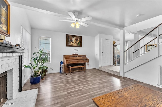 110 Huckleberry Ln, Henderson, NV 89074 - living area featuring a fireplace, a ceiling fan, wood finished floors, stairway, and baseboards