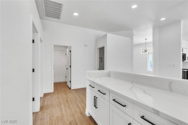 831 Purple Sage Ter, Henderson, NV 89015 - kitchen with white cabinets, light wood-style floors, a chandelier, baseboards, and recessed lighting