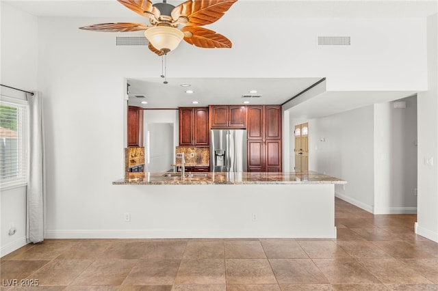 1505 Irene Dr, Boulder City, NV 89005 - kitchen featuring stainless steel fridge with ice dispenser, baseboards, ceiling fan, a peninsula, and light stone countertops