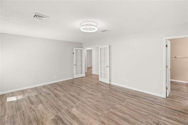 1505 Irene Dr, Boulder City, NV 89005 - unfurnished bedroom with french doors, wood finished floors, a textured ceiling, baseboards, and a spacious closet