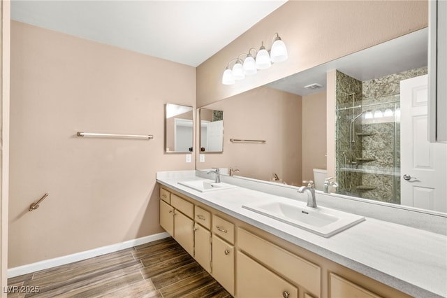 1505 Irene Dr, Boulder City, NV 89005 - bathroom with double vanity, wood finished floors, toilet, a stall shower, and baseboards