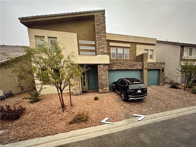 8738 Stella Nova St, Las Vegas, NV 89139 - view of front of house with stone siding, stucco siding, decorative driveway, and a balcony