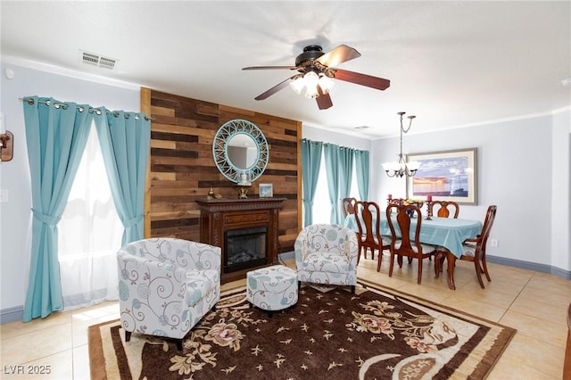 3404 Brayton Mist Dr, North Las Vegas, NV 89081 - tiled living area featuring crown molding, a ceiling fan, a fireplace, a chandelier, and baseboards