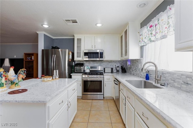 3404 Brayton Mist Dr, North Las Vegas, NV 89081 - kitchen featuring stainless steel appliances, a sink, tasteful backsplash, light tile patterned floors, and white cabinetry