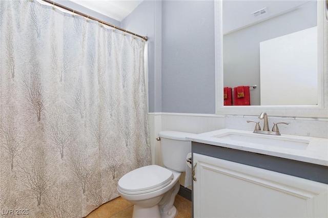 3404 Brayton Mist Dr, North Las Vegas, NV 89081 - bathroom featuring vanity, toilet, wainscoting, tile patterned flooring, and curtained shower