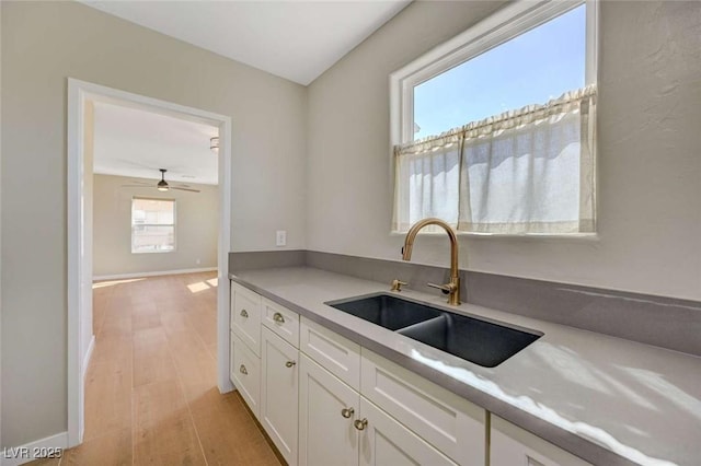 524 Hopi Pl, Boulder City, NV 89005 - kitchen featuring a sink, light wood-style floors, white cabinets, ceiling fan, and light countertops