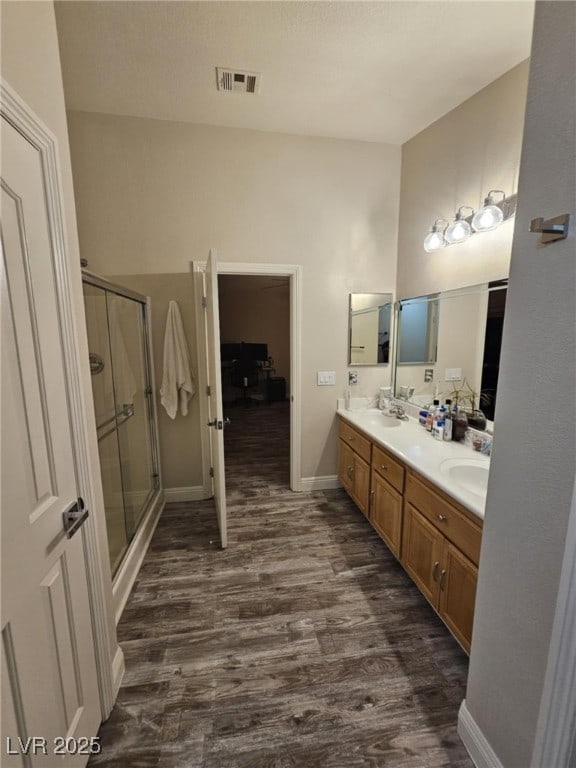 2077 Alki Beach Ave, Laughlin, NV 89029 - full bath with wood finished floors, a shower stall, double vanity, and baseboards