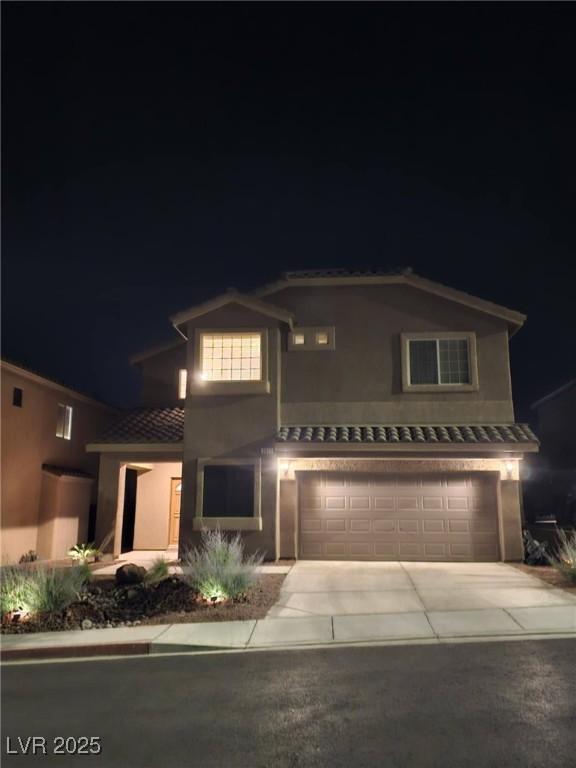 2077 Alki Beach Ave, Laughlin, NV 89029 - traditional home with a tile roof, a garage, stucco siding, and driveway