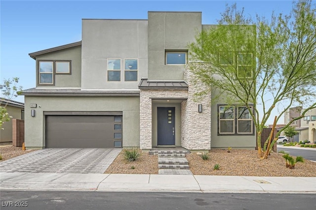 6830 Fallen Rock St, North Las Vegas, NV 89084 - modern home featuring an attached garage, stucco siding, a standing seam roof, driveway, and stone siding