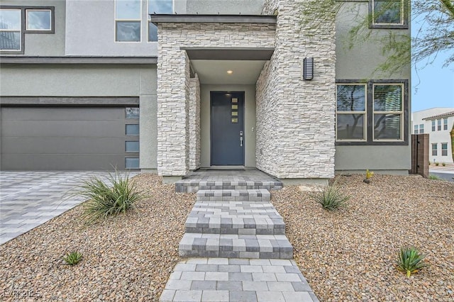 6830 Fallen Rock St, North Las Vegas, NV 89084 - property entrance with stone siding, stucco siding, a garage, and driveway
