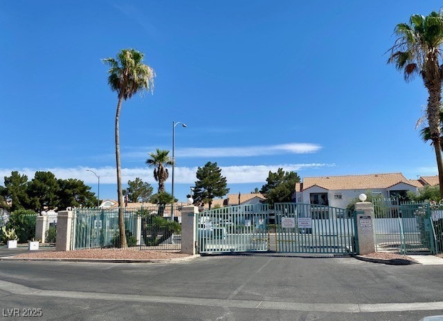 2725 S Nellis Blvd Unit 1158, Las Vegas, NV 89121 - view of asphalt road featuring a gate, curbs, a gated entry, and street lighting