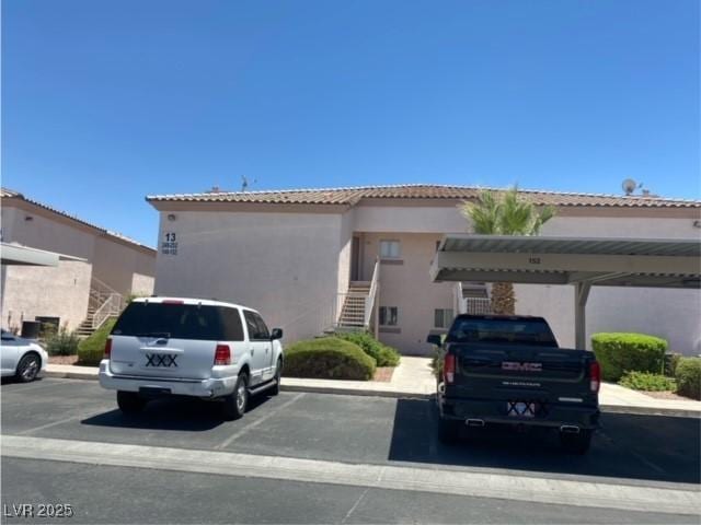 4555 Sahara Ave Unit 252, Las Vegas, NV 89104 - view of front facade featuring stairway, covered and uncovered parking, stucco siding, and a tile roof