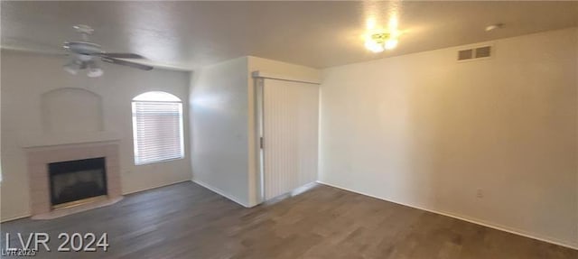 4555 Sahara Ave Unit 252, Las Vegas, NV 89104 - unfurnished living room featuring ceiling fan, wood finished floors, a fireplace, and baseboards