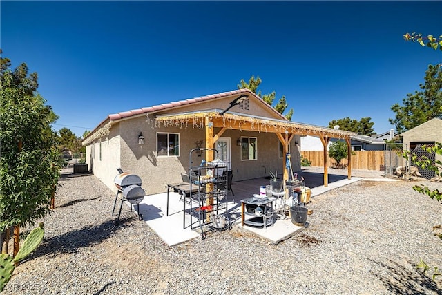 100 Eton St, Pahrump, NV 89048 - back of property with a fenced backyard, stucco siding, a patio area, and a tile roof