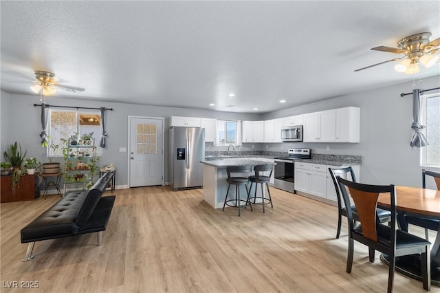 100 Eton St, Pahrump, NV 89048 - kitchen with stainless steel appliances, ceiling fan, a breakfast bar, a kitchen island, and recessed lighting