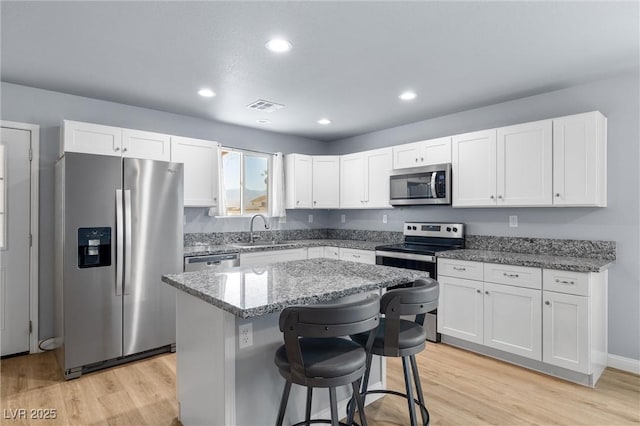 100 Eton St, Pahrump, NV 89048 - kitchen featuring appliances with stainless steel finishes, light wood-style floors, white cabinets, and recessed lighting