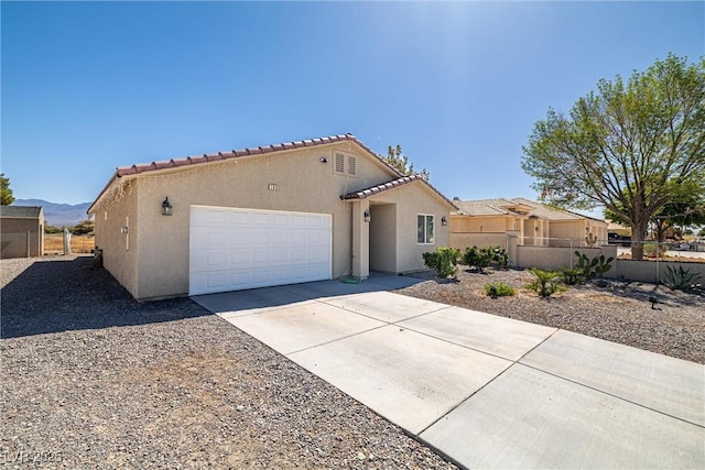 100 Eton St, Pahrump, NV 89048 - mediterranean / spanish house with a garage, stucco siding, concrete driveway, a tile roof, and a mountain view