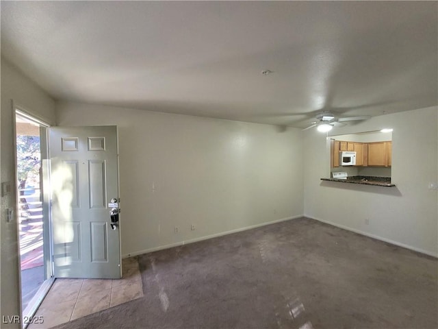 7730 Secret Shore Dr Unit 207, Las Vegas, NV 89128 - unfurnished living room featuring ceiling fan, carpet flooring, and baseboards