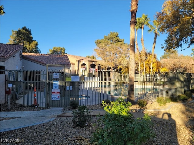7730 Secret Shore Dr Unit 207, Las Vegas, NV 89128 - view of front of property with a tiled roof, stucco siding, and a gate