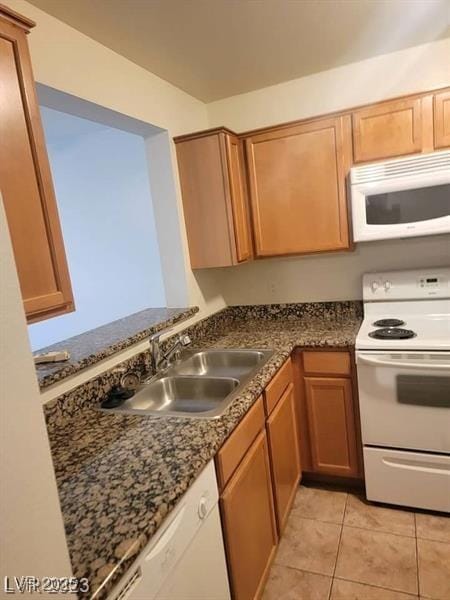 7730 Secret Shore Dr Unit 207, Las Vegas, NV 89128 - kitchen featuring white appliances, a sink, light tile patterned flooring, and dark stone countertops