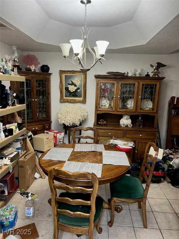 1407 Santa Margarita St Unit A, Las Vegas, NV 89146 - dining room with light tile patterned floors, a chandelier, and a tray ceiling