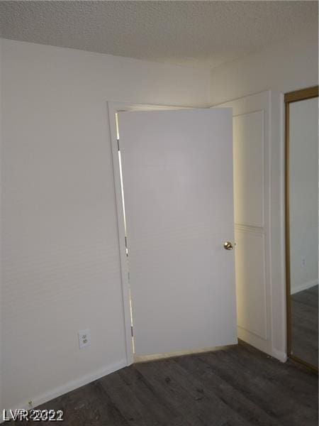 1608 N Torrey Pines Dr Unit 103, Las Vegas, NV 89108 - empty room with dark wood-style flooring, a textured ceiling, and baseboards