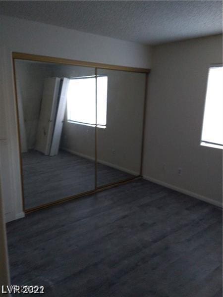 1608 N Torrey Pines Dr Unit 103, Las Vegas, NV 89108 - unfurnished bedroom featuring wood finished floors, baseboards, a textured ceiling, and a closet