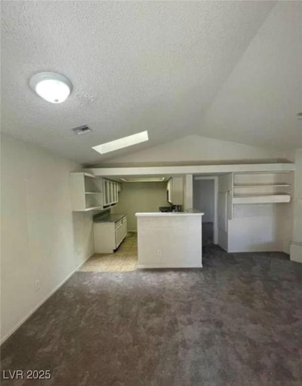 2995 E Sunset Rd Unit 237, Las Vegas, NV 89120 - unfurnished living room featuring carpet, vaulted ceiling, and a textured ceiling