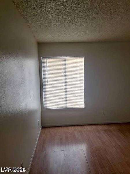 3435 Villa Knolls S Dr, Las Vegas, NV 89120 - unfurnished room with wood finished floors, a textured ceiling, and baseboards