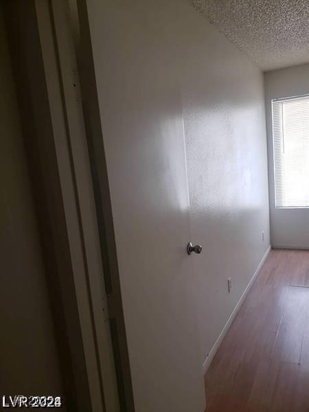 3435 Villa Knolls S Dr, Las Vegas, NV 89120 - hallway with a textured ceiling, light wood finished floors, and baseboards