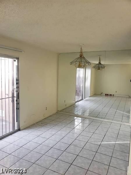 3435 Villa Knolls S Dr, Las Vegas, NV 89120 - empty room featuring plenty of natural light, light tile patterned floors, and a textured ceiling