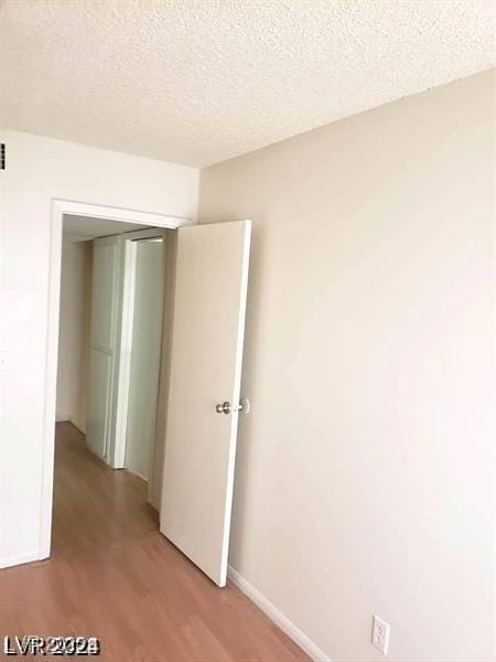 3435 Villa Knolls S Dr, Las Vegas, NV 89120 - unfurnished room with light wood-style floors, a textured ceiling, and baseboards
