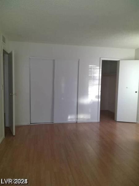 3435 Villa Knolls S Dr, Las Vegas, NV 89120 - unfurnished bedroom featuring wood finished floors and multiple closets