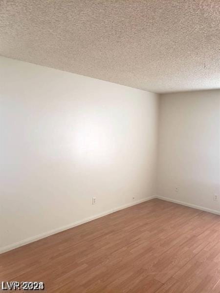 3435 Villa Knolls S Dr, Las Vegas, NV 89120 - spare room featuring light wood-type flooring, a textured ceiling, and baseboards