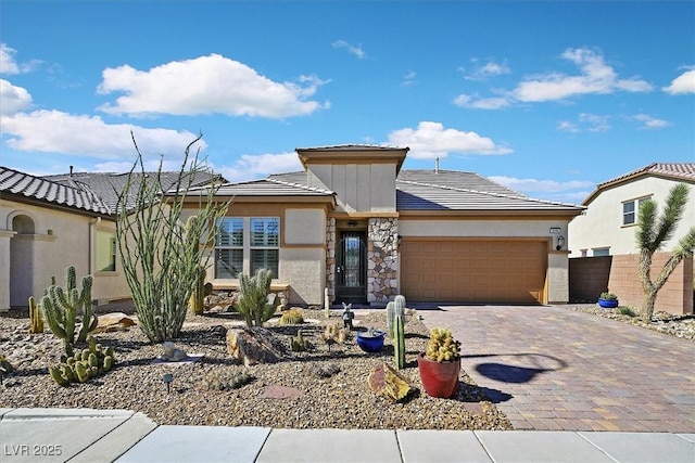 3096 Beaux Art Ave, Henderson, NV 89044 - view of front of house with an attached garage, stucco siding, decorative driveway, and a tiled roof