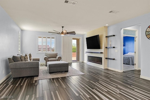 3096 Beaux Art Ave, Henderson, NV 89044 - living area with baseboards, dark wood finished floors, a large fireplace, and a ceiling fan