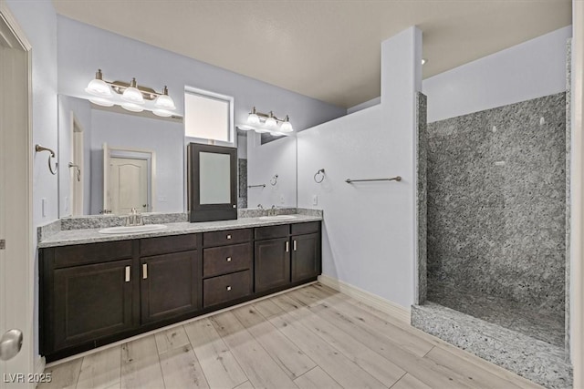 3096 Beaux Art Ave, Henderson, NV 89044 - full bathroom featuring a walk in shower, double vanity, wood finished floors, and baseboards