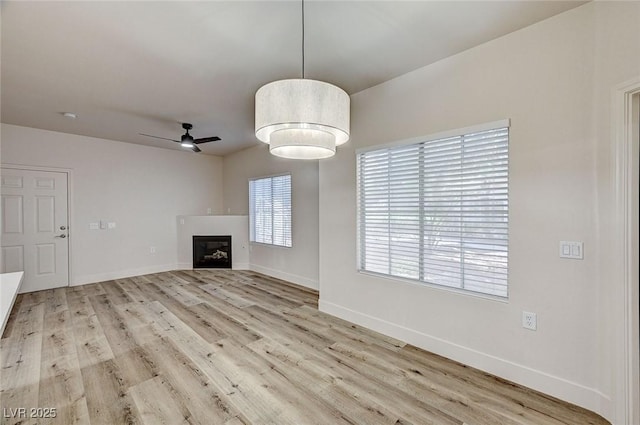 3400 Cabana Dr Unit 1048, Las Vegas, NV 89122 - unfurnished living room featuring a ceiling fan, wood finished floors, a fireplace, and baseboards