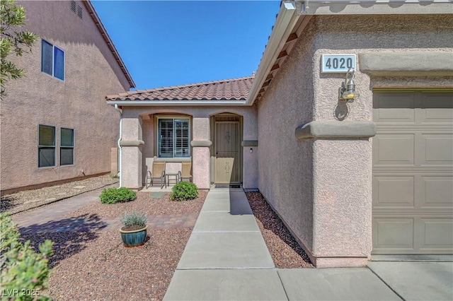 4020 Driscoll Mountain St, Las Vegas, NV 89129 - view of exterior entry with a tile roof, stucco siding, and a garage