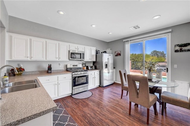 4020 Driscoll Mountain St, Las Vegas, NV 89129 - kitchen with stainless steel appliances, a sink, dark wood finished floors, white cabinetry, and recessed lighting