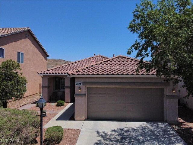 4020 Driscoll Mountain St, Las Vegas, NV 89129 - mediterranean / spanish-style house featuring concrete driveway, a tile roof, stucco siding, and an attached garage