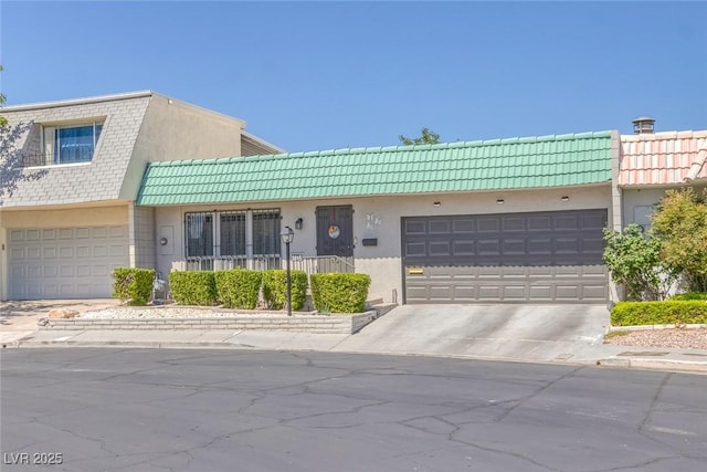 3815 Atlantis St, Las Vegas, NV 89121 - multi unit property featuring driveway, a tile roof, stucco siding, and a garage