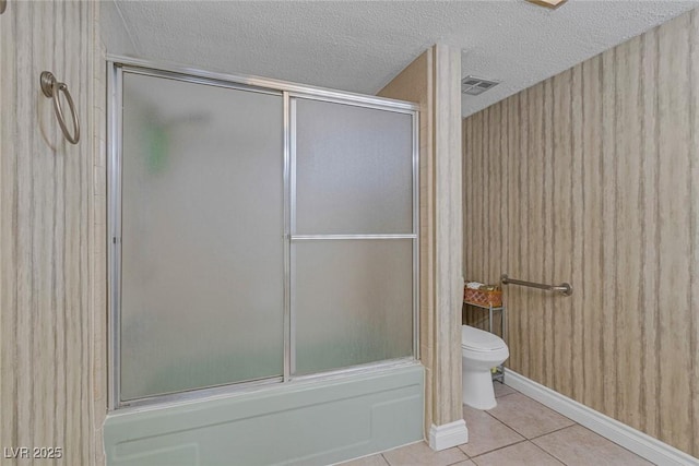 3815 Atlantis St, Las Vegas, NV 89121 - bathroom with toilet, tile patterned floors, a textured ceiling, and shower / bath combination with glass door