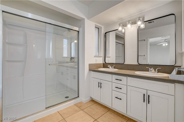 6521 Faith Peak Dr, Las Vegas, NV 89108 - bathroom with tile patterned flooring, double vanity, a shower stall, and a ceiling fan