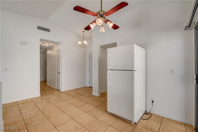 6521 Faith Peak Dr, Las Vegas, NV 89108 - kitchen with freestanding refrigerator, a ceiling fan, light tile patterned flooring, a chandelier, and high vaulted ceiling